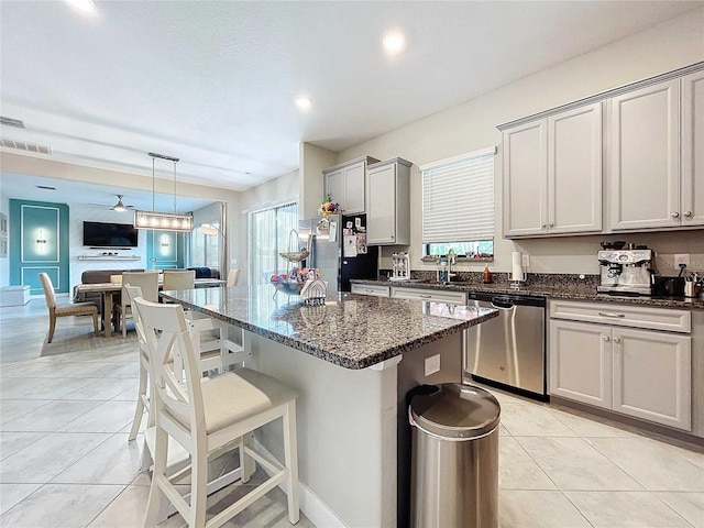 kitchen featuring appliances with stainless steel finishes, gray cabinetry, ceiling fan, hanging light fixtures, and light tile patterned flooring