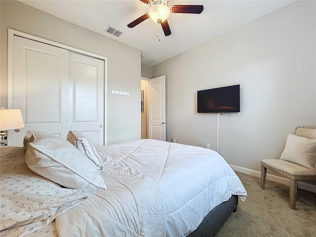 carpeted bedroom with ceiling fan and a closet