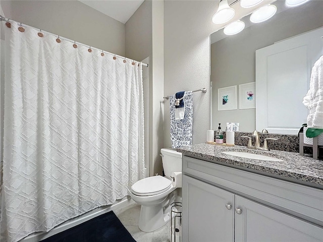 bathroom featuring tile patterned flooring, vanity, and toilet