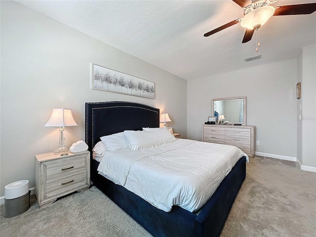 carpeted bedroom with a textured ceiling and ceiling fan