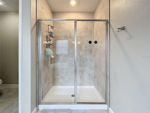 bathroom featuring a shower with door