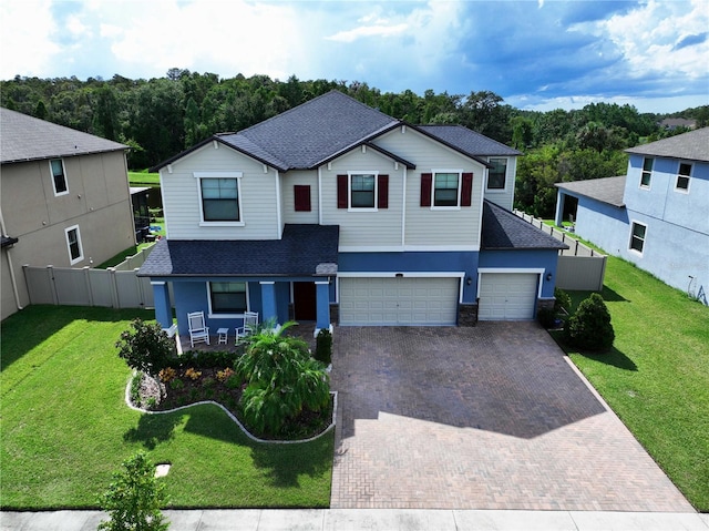 view of front of home featuring a front lawn, covered porch, and a garage