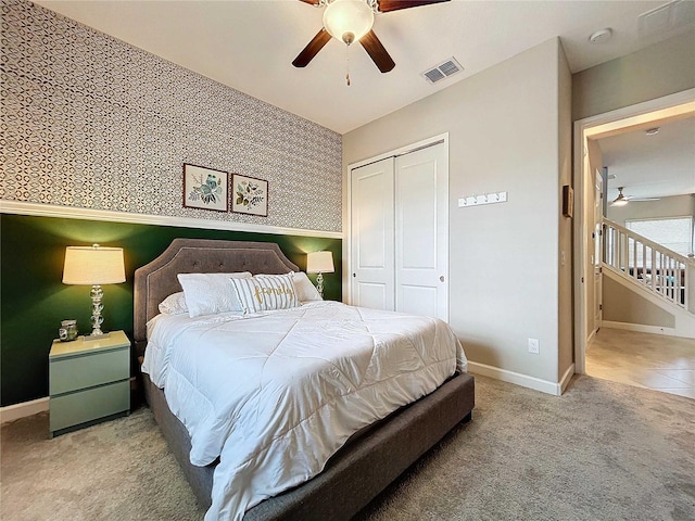 carpeted bedroom featuring ceiling fan and a closet