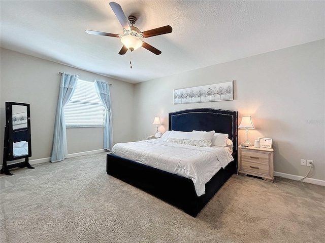 bedroom featuring a textured ceiling, ceiling fan, and light carpet