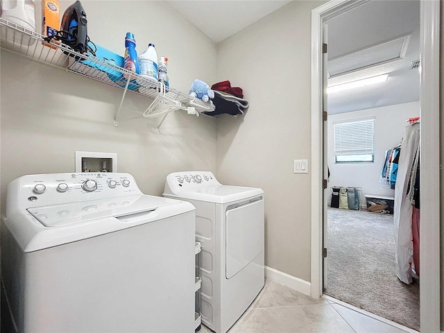 clothes washing area with light colored carpet and washer and clothes dryer