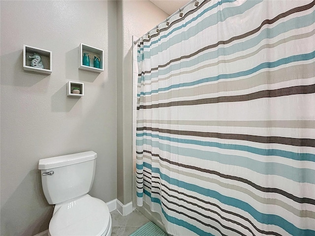 bathroom featuring tile patterned flooring, a shower with curtain, and toilet