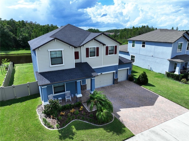 view of front of house featuring covered porch, a front yard, and a garage