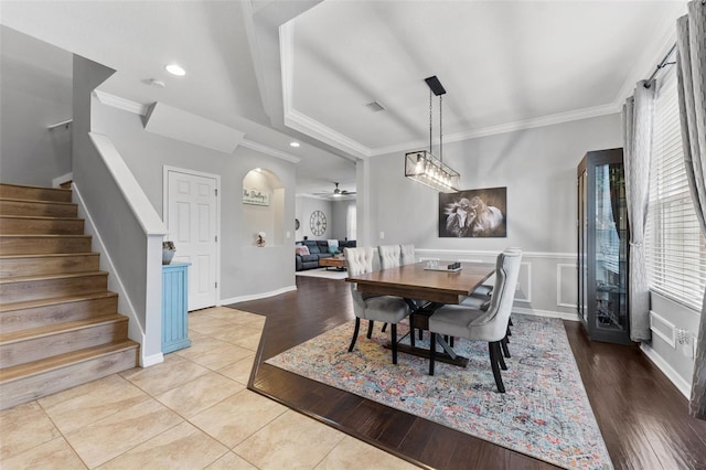 tiled dining area with ornamental molding and ceiling fan