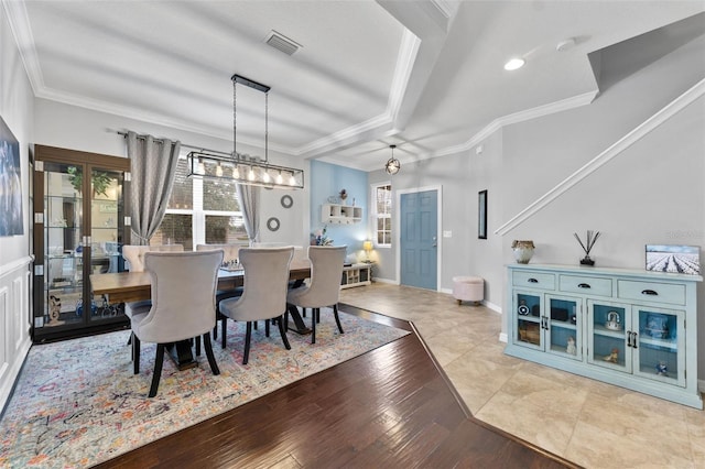 dining space with a notable chandelier, ornamental molding, and light hardwood / wood-style flooring