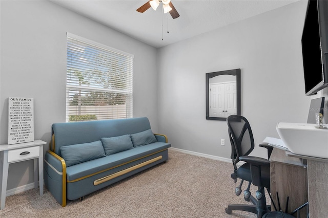 carpeted home office featuring ceiling fan