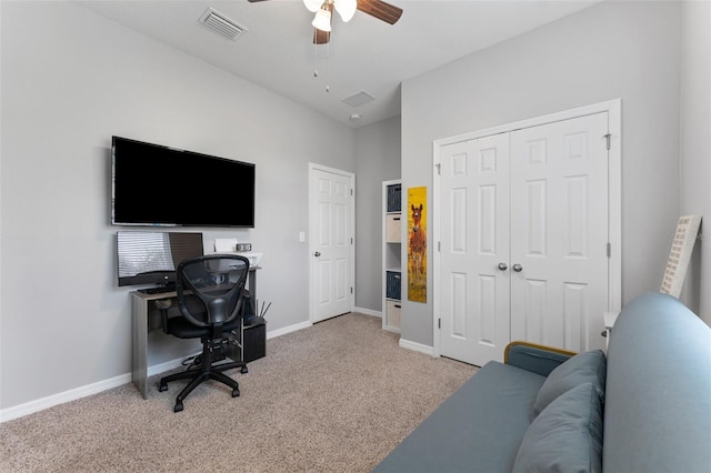 carpeted home office featuring ceiling fan