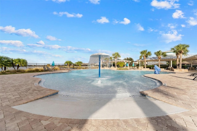 view of swimming pool with pool water feature and a patio area