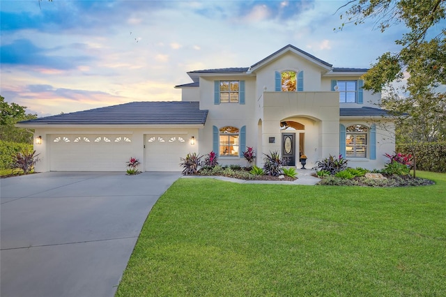 view of front of property with a garage and a lawn