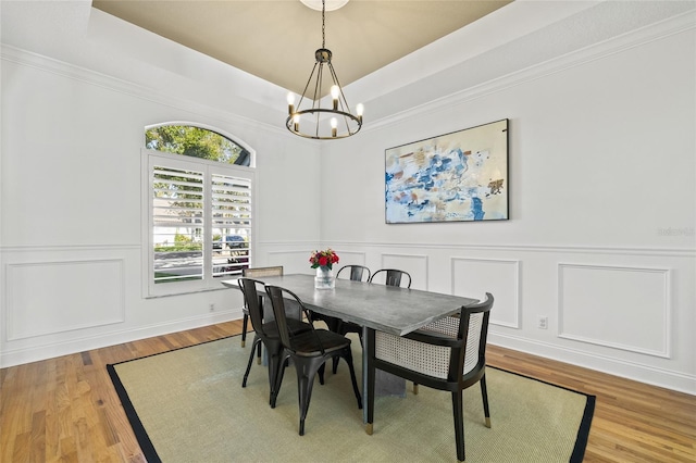 dining room featuring a tray ceiling, an inviting chandelier, and wood-type flooring