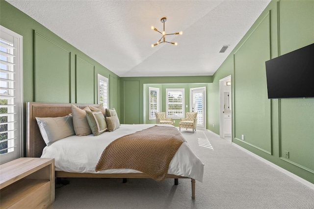 carpeted bedroom with lofted ceiling and an inviting chandelier