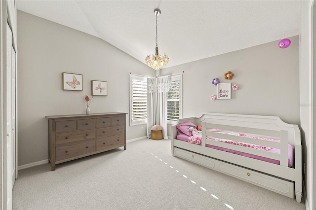 carpeted bedroom with a textured ceiling, a chandelier, and vaulted ceiling