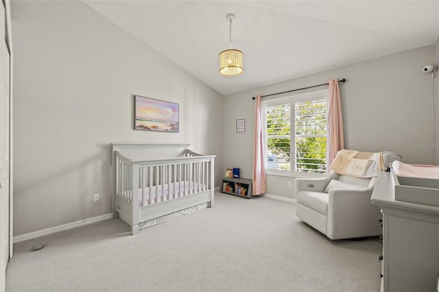 carpeted bedroom with vaulted ceiling and a crib