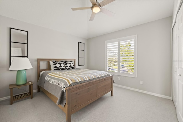 bedroom featuring a closet, ceiling fan, light carpet, and lofted ceiling