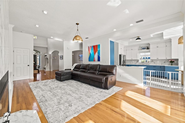 living room featuring crown molding and light wood-type flooring