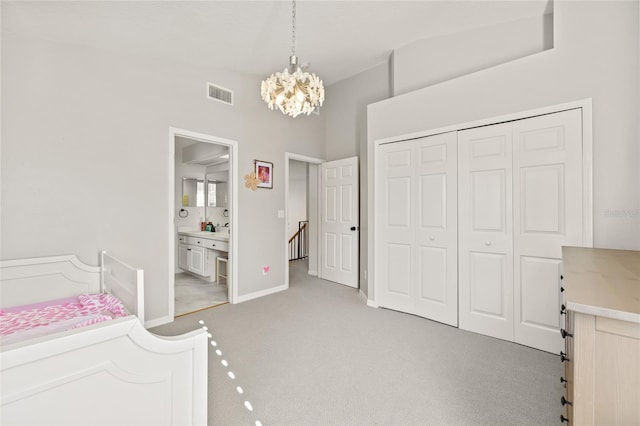 bedroom featuring a closet, vaulted ceiling, a chandelier, and light carpet