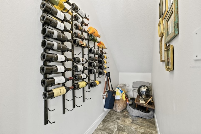 wine area with a textured ceiling and vaulted ceiling