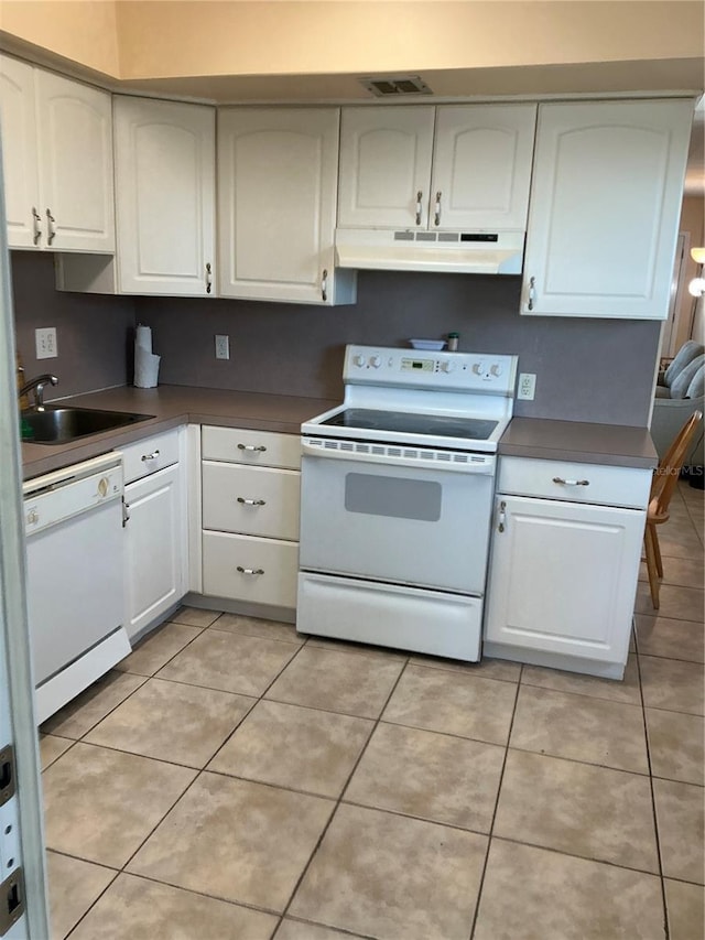 kitchen featuring sink, light tile patterned floors, white cabinets, and white appliances