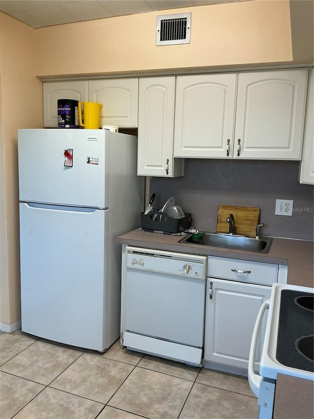 kitchen featuring sink, light tile patterned floors, white cabinets, and white appliances