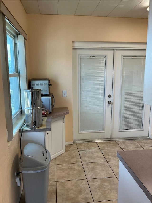 doorway with light tile patterned floors and french doors