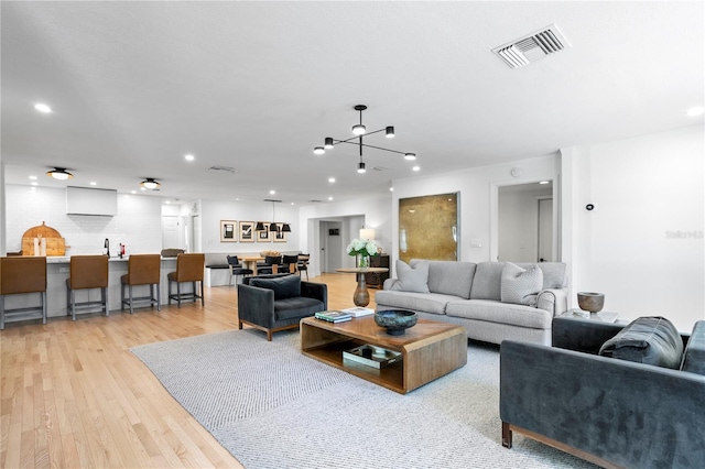 living room featuring an inviting chandelier and light hardwood / wood-style flooring