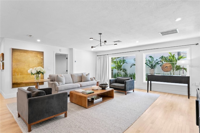 living room with light hardwood / wood-style floors and a textured ceiling