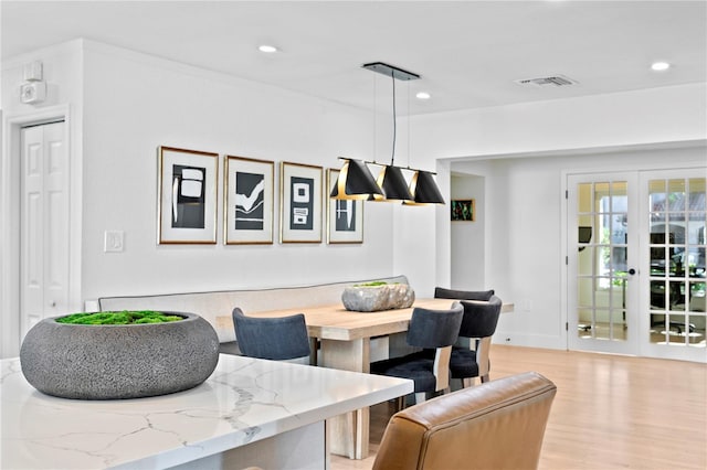 dining area with french doors, light hardwood / wood-style floors, and breakfast area