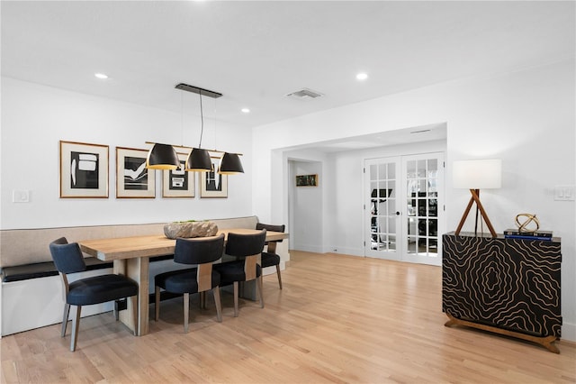 dining room featuring french doors and light hardwood / wood-style flooring