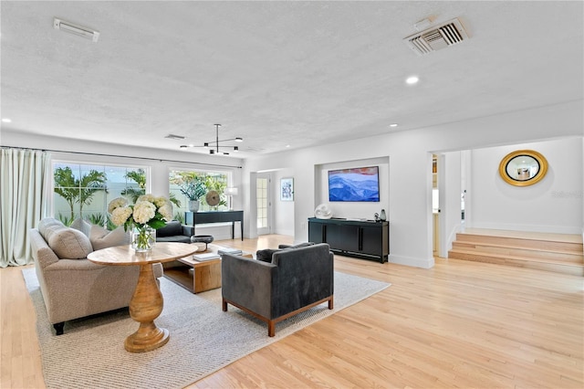 living room featuring light hardwood / wood-style flooring and a textured ceiling