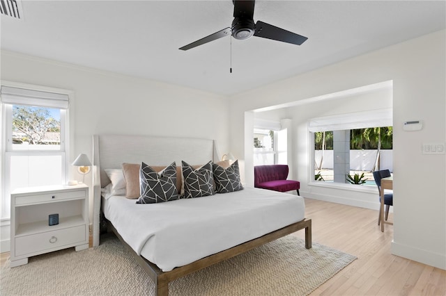 bedroom featuring multiple windows, wood-type flooring, and ceiling fan