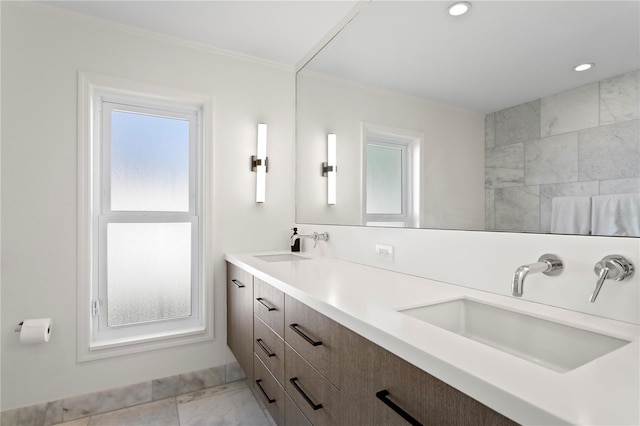 bathroom featuring crown molding, a healthy amount of sunlight, and vanity