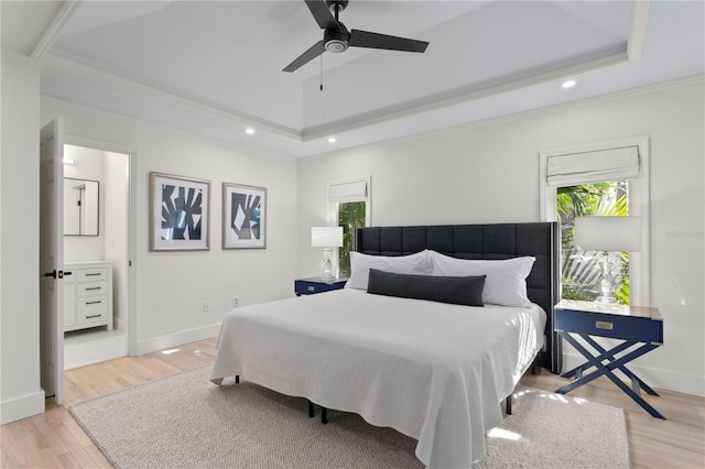 bedroom featuring ceiling fan, ornamental molding, a tray ceiling, and light hardwood / wood-style flooring