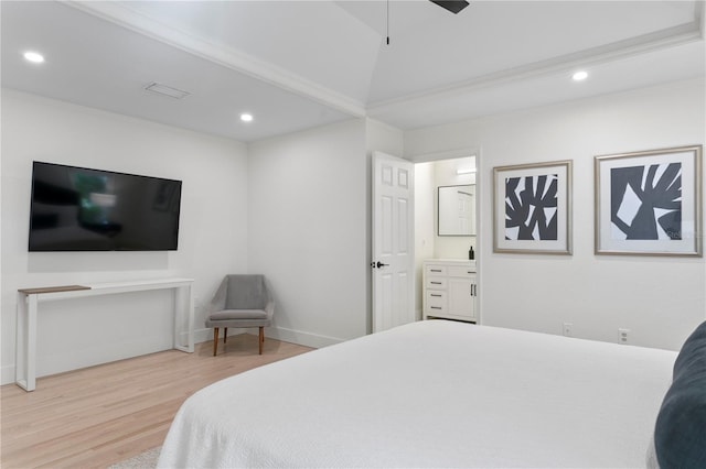 bedroom with vaulted ceiling, hardwood / wood-style floors, connected bathroom, ornamental molding, and ceiling fan