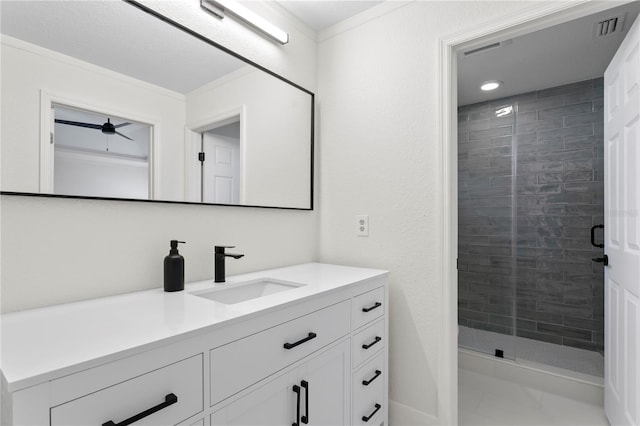 bathroom with vanity, an enclosed shower, and ornamental molding