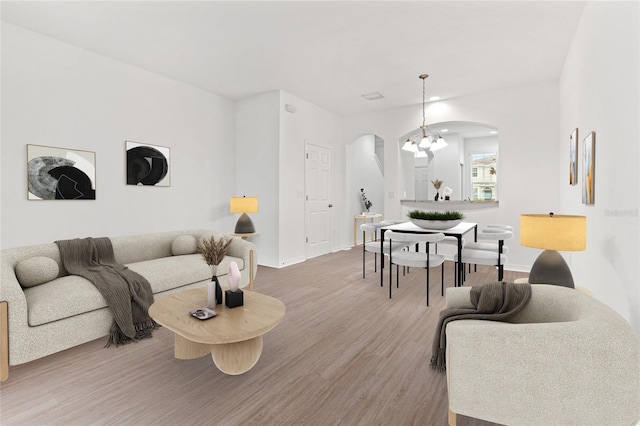 living room featuring wood-type flooring and a chandelier