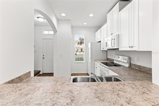 kitchen featuring sink, white cabinets, and white appliances