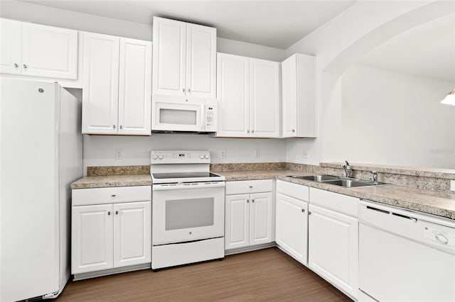 kitchen with white cabinets, white appliances, light hardwood / wood-style flooring, and sink