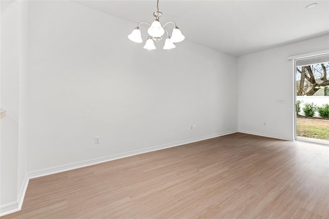 unfurnished room featuring light hardwood / wood-style flooring and a notable chandelier