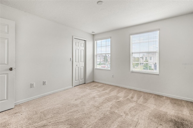 carpeted spare room with a textured ceiling