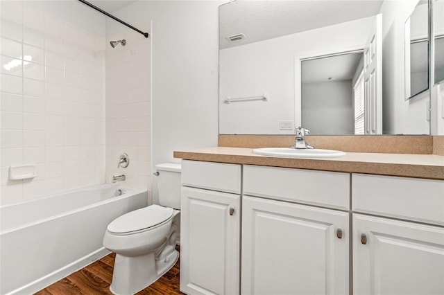 full bathroom featuring wood-type flooring, vanity, toilet, and tiled shower / bath