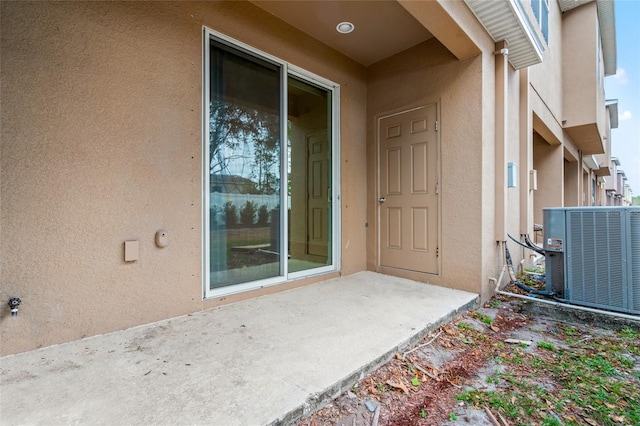 doorway to property with a patio area and central AC unit