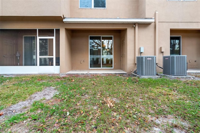 back of house with central AC unit, a sunroom, and a patio area