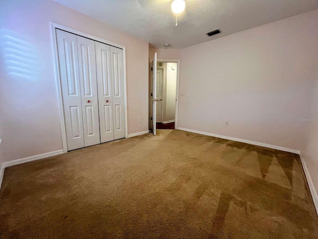 unfurnished bedroom featuring a closet, ceiling fan, and carpet flooring