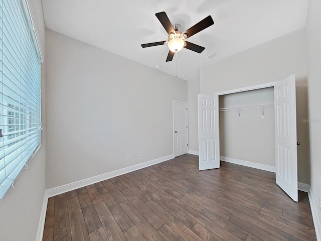 unfurnished bedroom featuring ceiling fan, dark wood-type flooring, and a closet