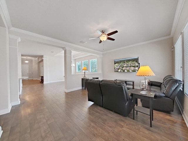 living room featuring hardwood / wood-style floors, decorative columns, ceiling fan, and ornamental molding