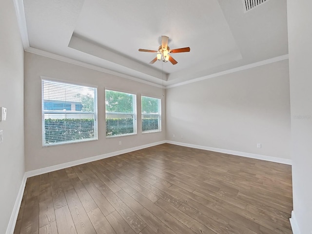 spare room with hardwood / wood-style flooring, a raised ceiling, ceiling fan, and crown molding